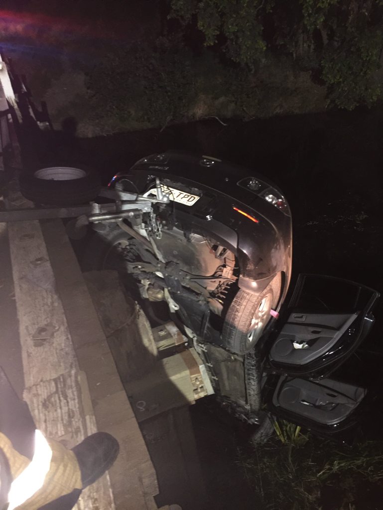 The car suspended over Running Creek by its tow bar. The car suspended over Running Creek by its tow bar.